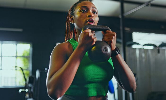 žena zvedající kettlebell